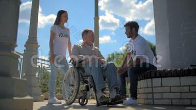 积极的<strong>国际志愿者</strong>与一个坐在轮椅上的人交谈